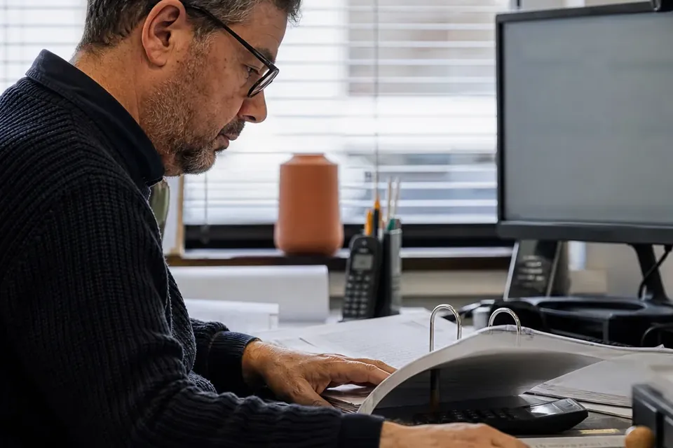 Attorney reading through a contract binder at an office desk
