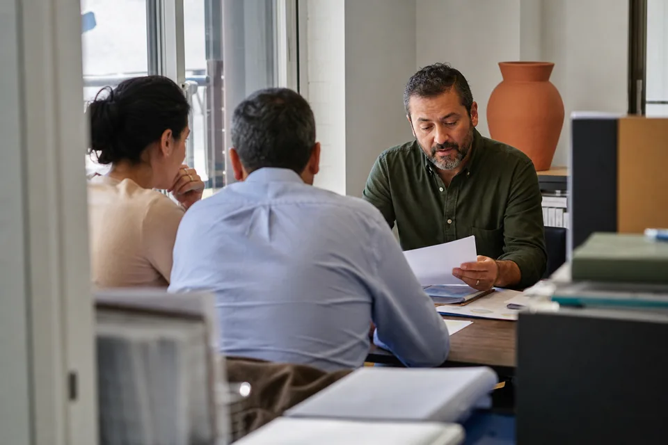 Finance executive presenting a monthly budget review to two colleagues